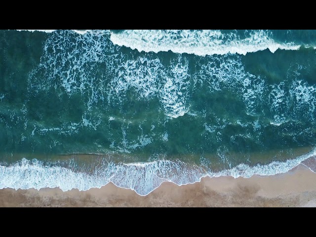Aerial view of sand beach. Top view sea waves. Drone footage